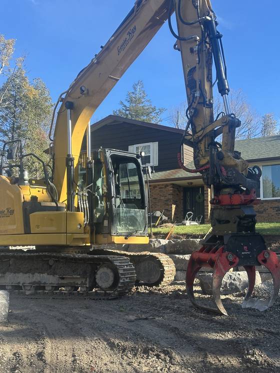 Excavator at a rural property driveway