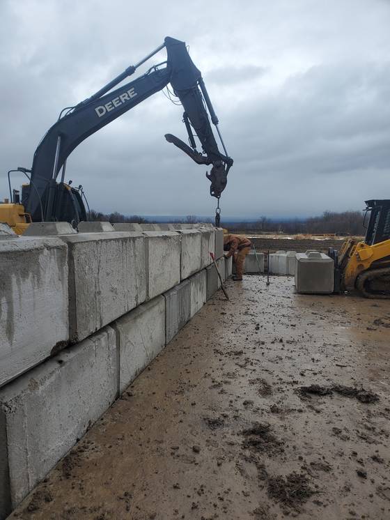 Excavator setting concrete blocks